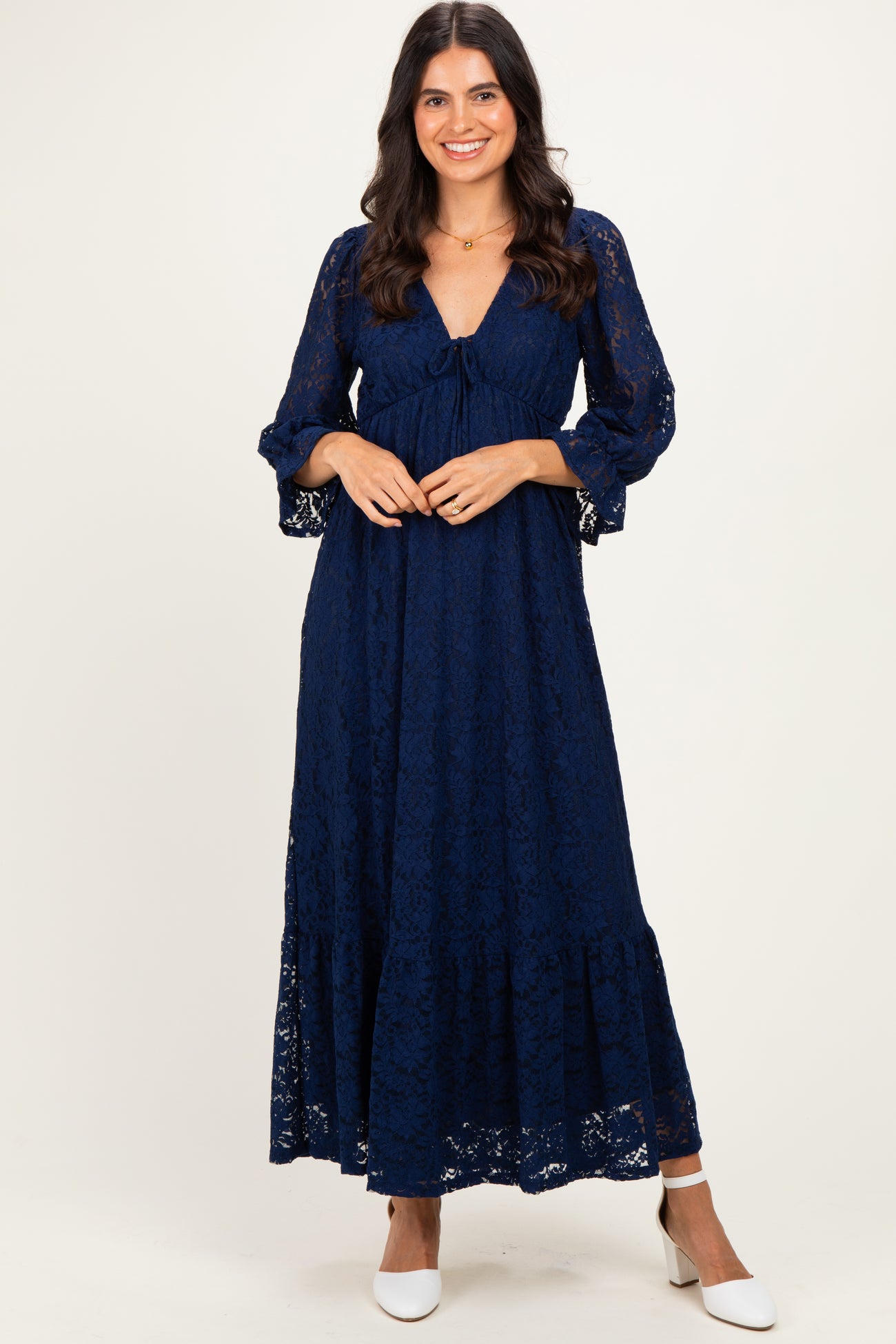 woman wearing a navy blue lace maxi dress with a tie front and bell sleeves