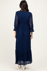 woman wearing a navy blue lace maxi dress with three-quarter sleeves and a tiered hem, viewed from the back