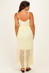 woman wearing a yellow lace maternity dress with a high-low hem and spaghetti straps, view from the back