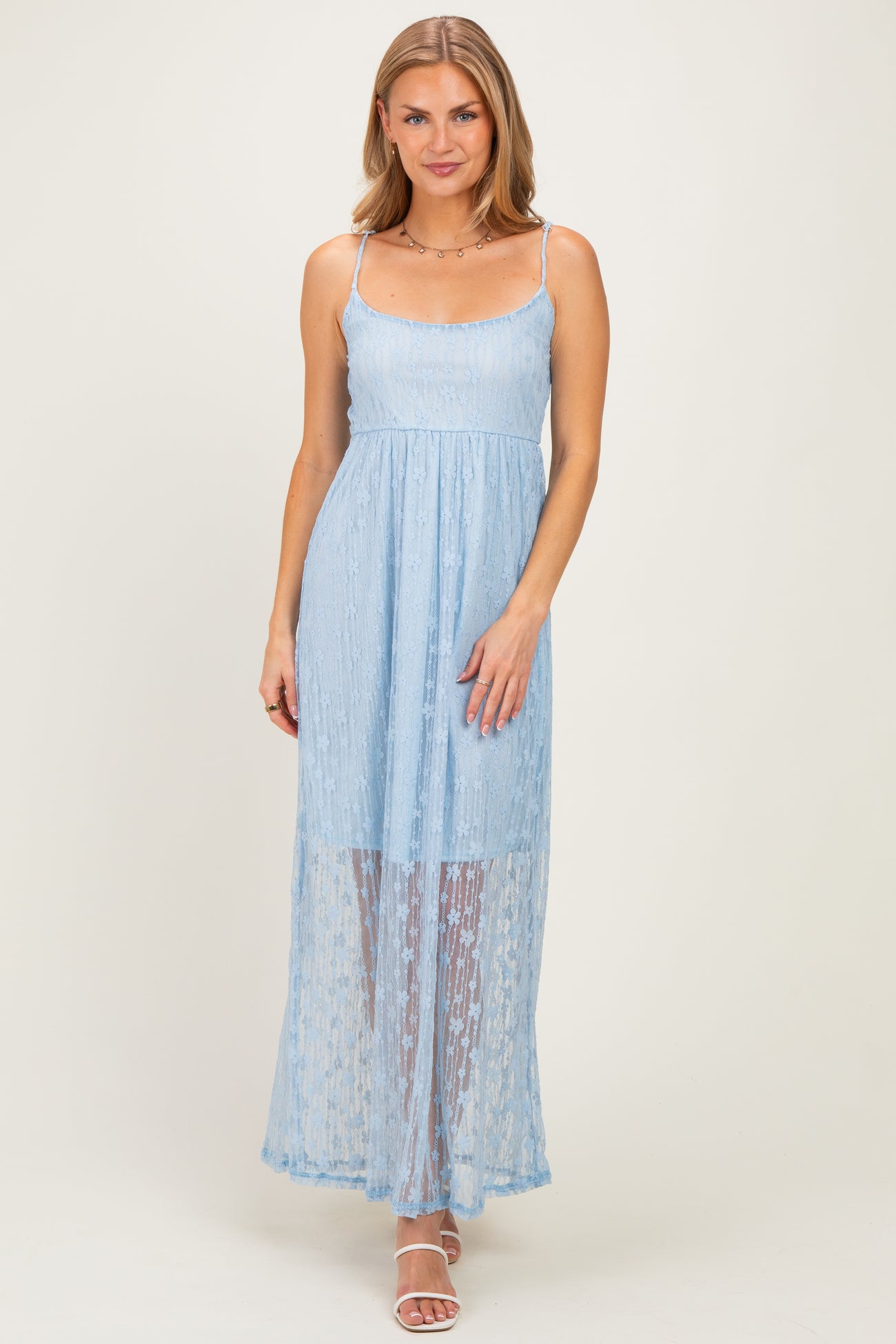 woman wearing a light blue maxi dress with lace overlay and thin straps