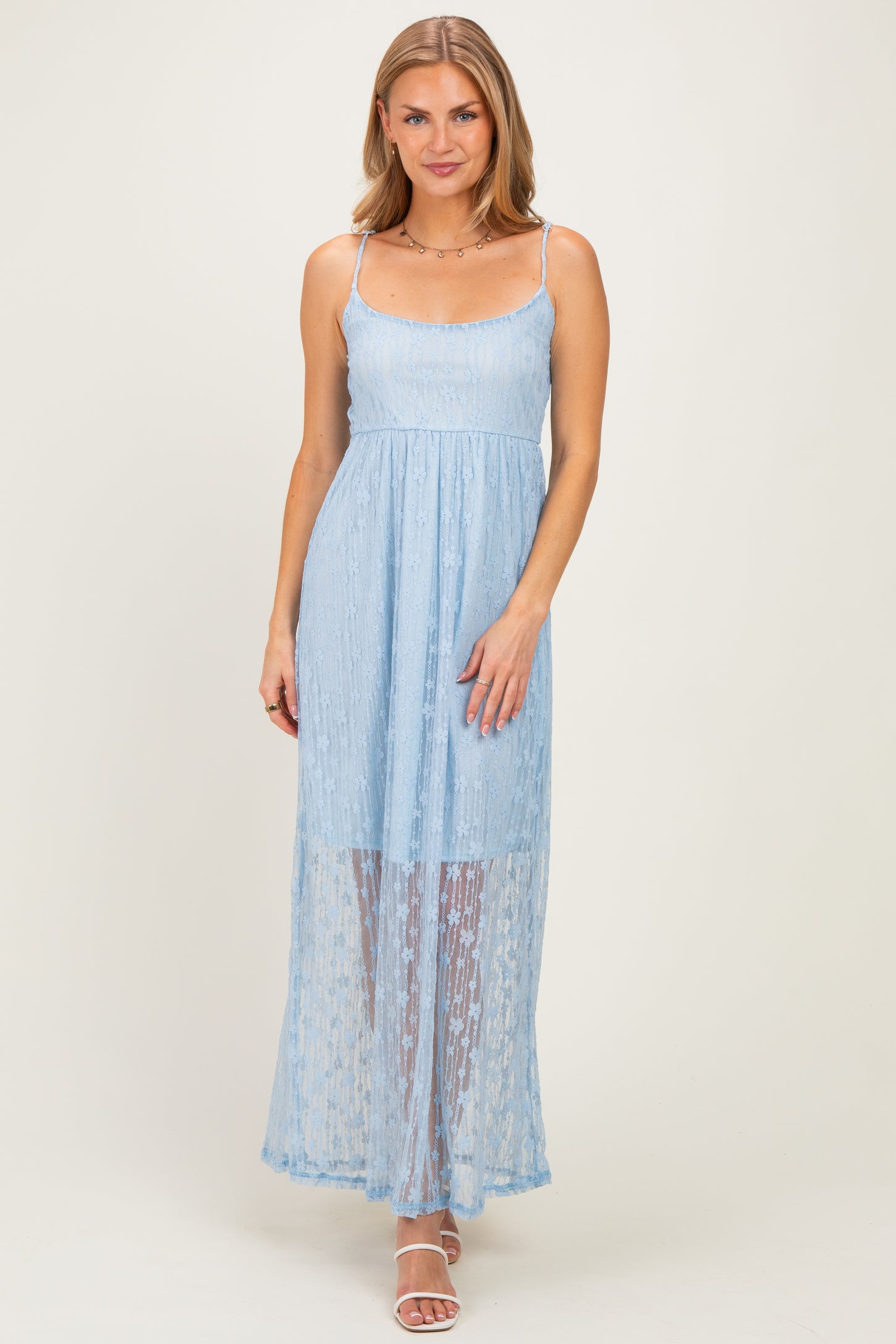 woman wearing a light blue maxi dress with lace overlay and thin straps