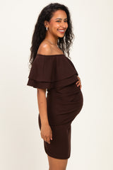 woman wearing a brown off-the-shoulder maternity dress with ruffle details and showing her baby bump