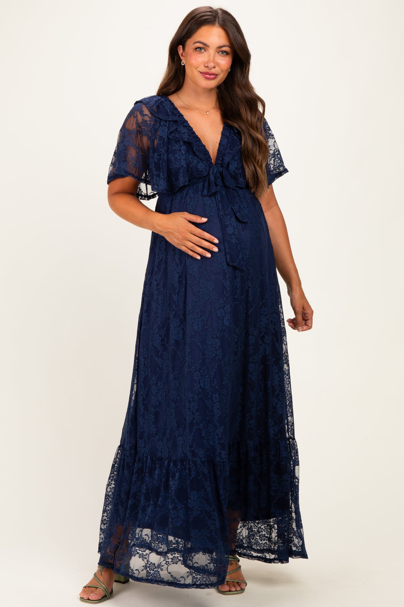 woman wearing a navy blue lace maternity maxi dress with ruffle details and a visible baby bump