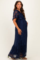 woman wearing a navy blue lace maternity maxi dress with ruffle sleeves and a visible baby bump