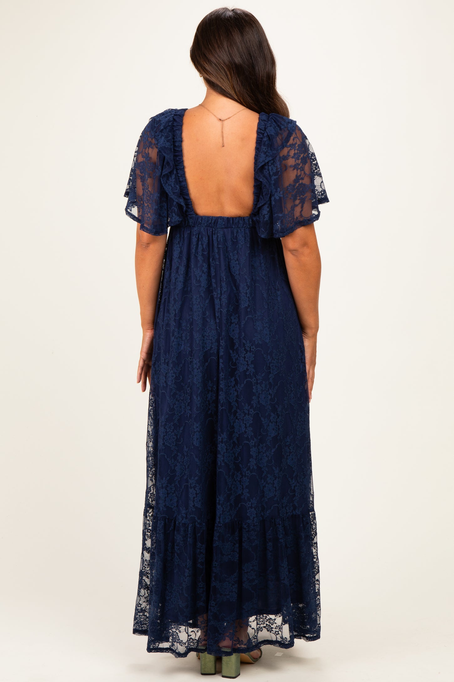 woman wearing a navy blue lace maternity maxi dress with flutter sleeves and a low back design
