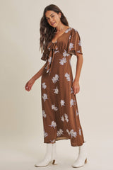 woman wearing a brown floral maxi dress with short sleeves and a tie front detail