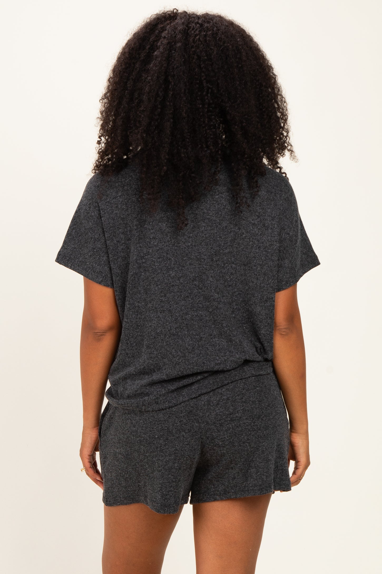 woman wearing a gray short sleeve loungewear set, showing the back view with a relaxed fit and comfortable shorts