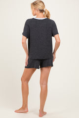 woman wearing a black maternity pajama set with a short sleeve top and shorts, showing a relaxed fit