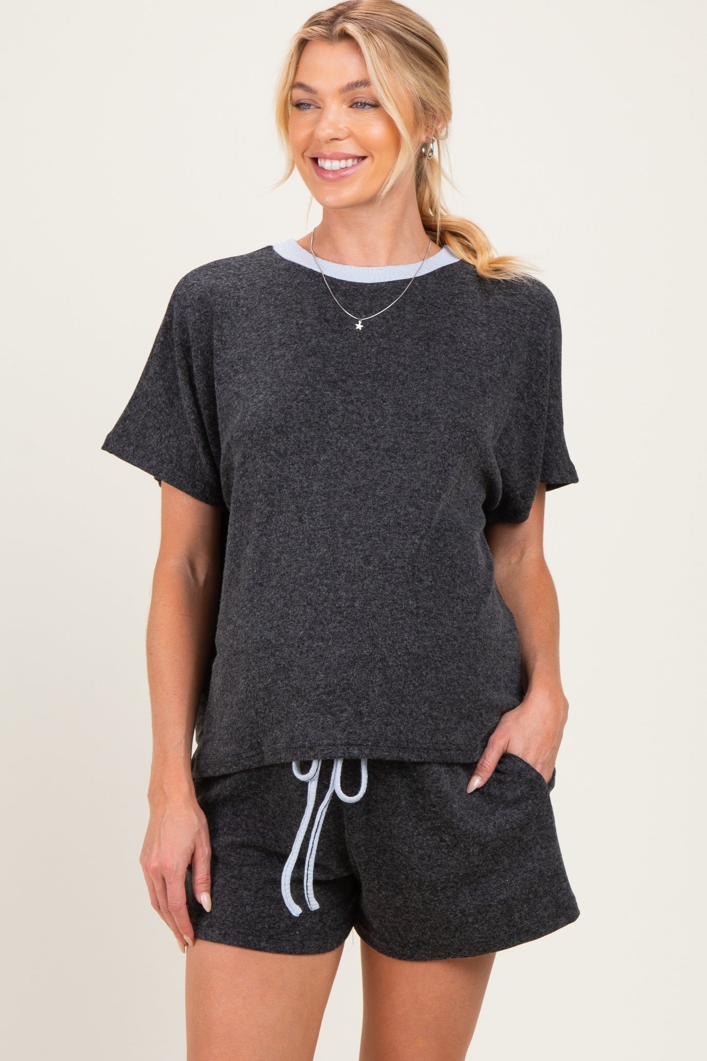 woman wearing a dark gray maternity lounge set with a short sleeve top and matching shorts, showing a comfortable style