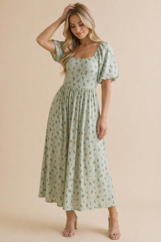 woman wearing a mint green floral midi dress with puff sleeves and a square neckline