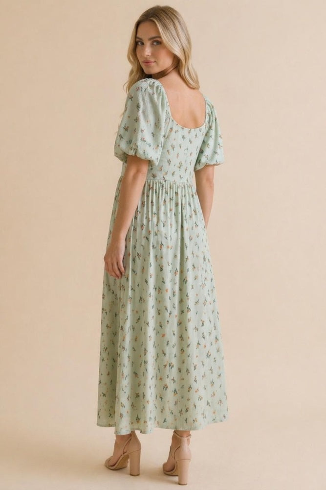 woman wearing a mint green floral maxi dress with puff sleeves, showing the back view and a relaxed fit