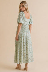 woman wearing a mint green floral maxi dress with puff sleeves, showing the back view and a relaxed fit