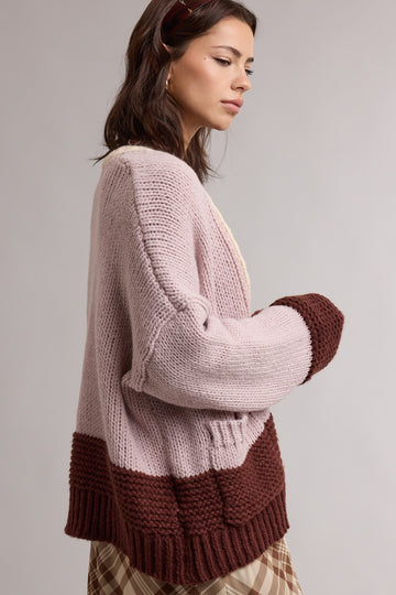 woman wearing a light pink and brown color-block oversized knit cardigan