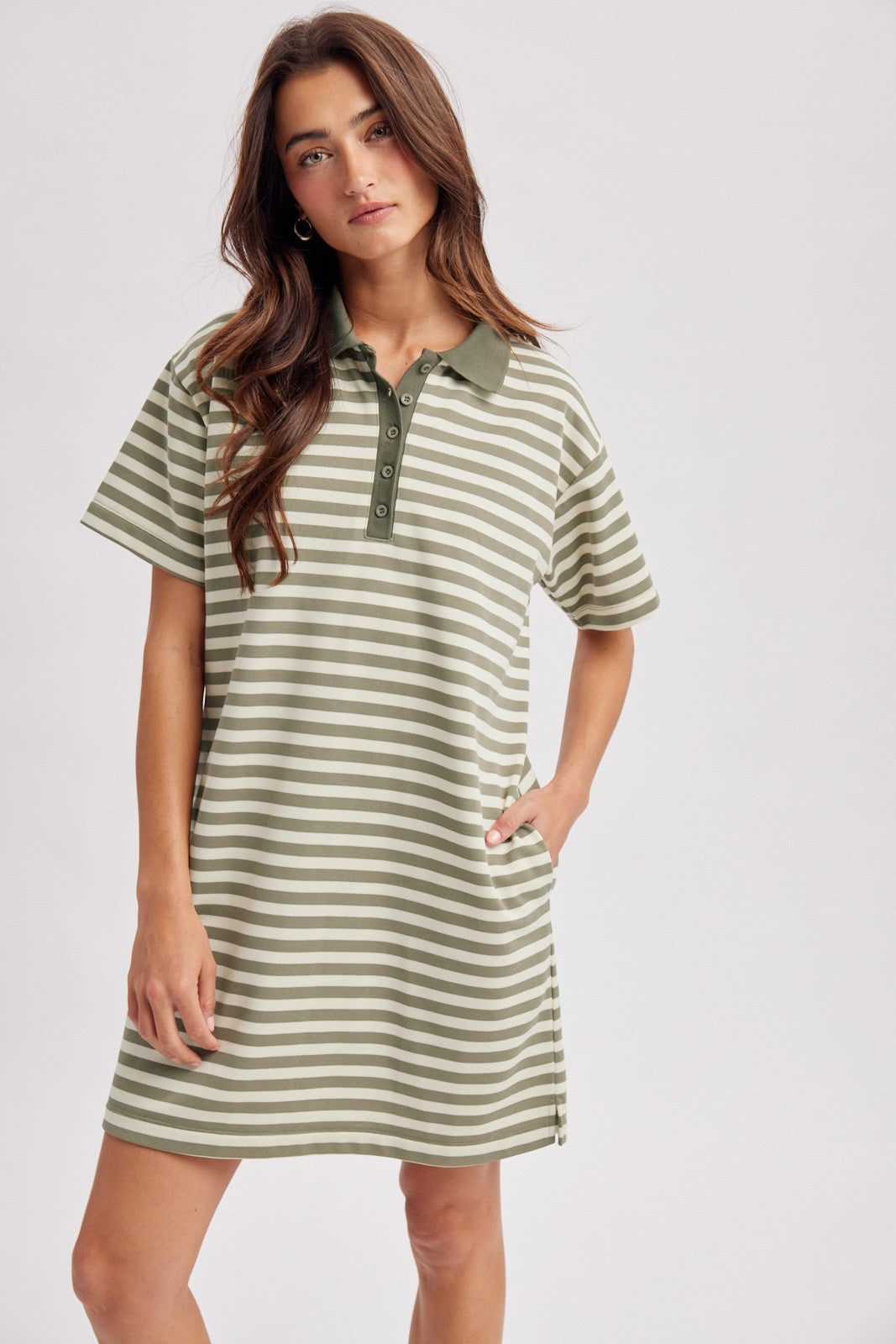 woman wearing a green and white striped polo dress with short sleeves and a button-down collar