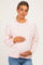 woman wearing a pink and white striped maternity sweater and holding her baby bump