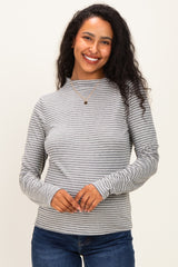 woman wearing a grey and white striped long sleeve maternity top with a round neckline and smiling