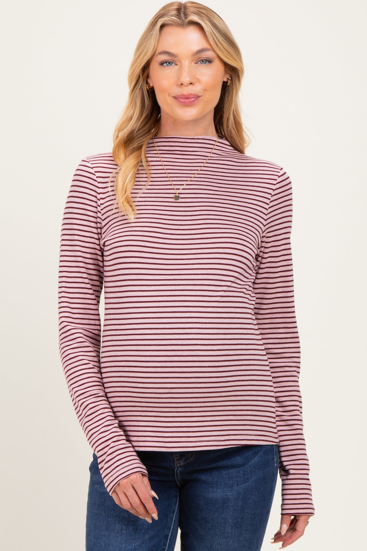 woman wearing a maroon and pink striped long sleeve maternity top with a high neckline and fitted style