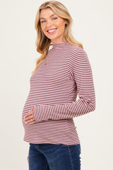 woman wearing a red and white striped maternity top and showing her baby bump