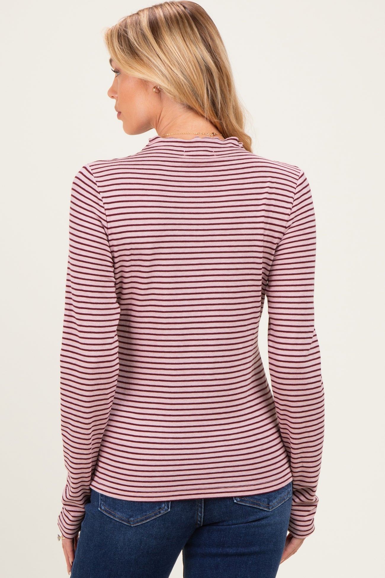 woman wearing a burgundy and cream striped maternity top, viewed from the back with fitted long sleeves