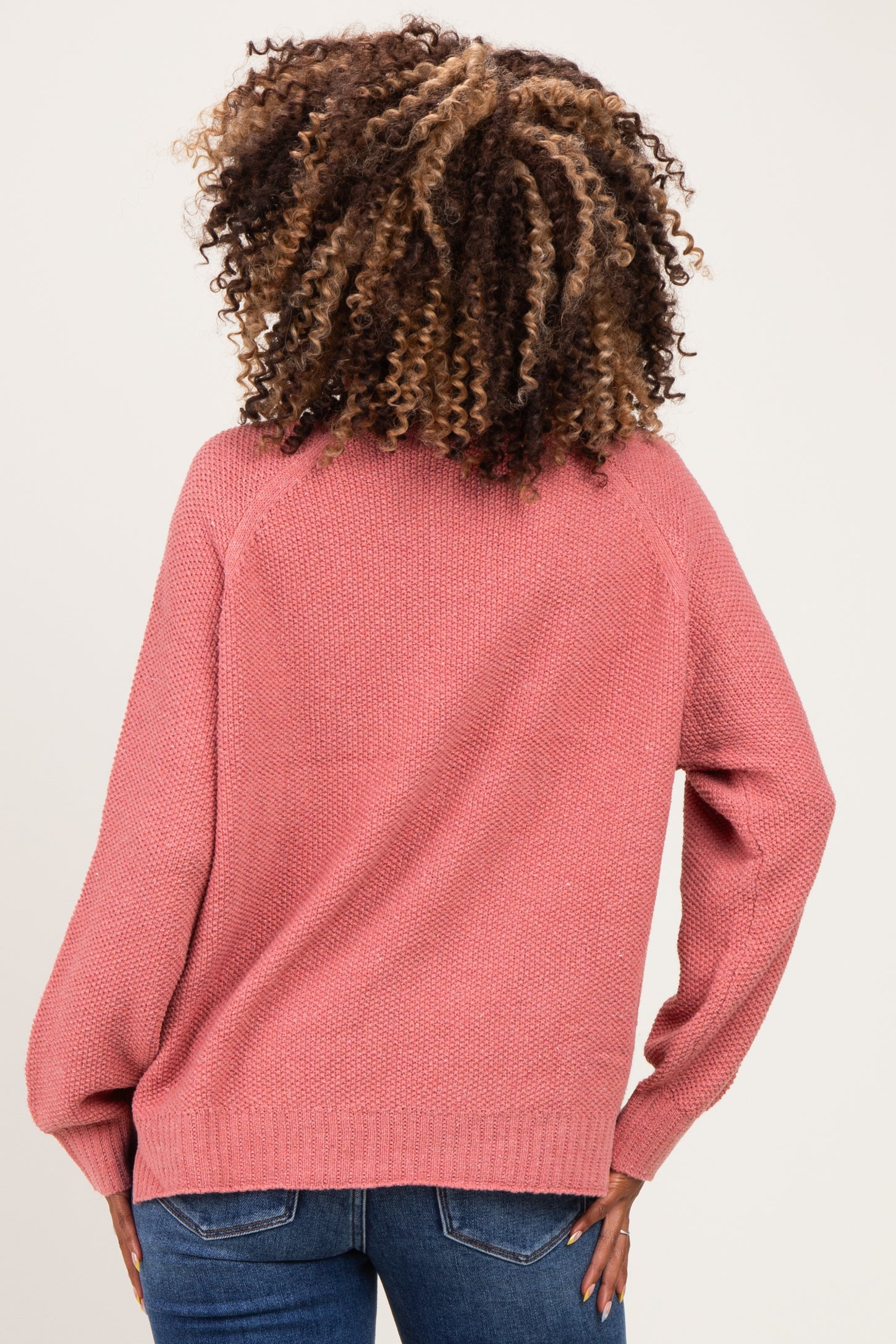 woman wearing a light pink maternity sweater with balloon sleeves, shown from the back