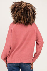 woman wearing a light pink maternity sweater with balloon sleeves, shown from the back