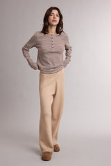 woman wearing a cream and burgundy striped long sleeve top and beige wide-leg pants