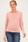 woman wearing a striped maternity top in coral and peach with a henley neckline and long sleeves, showing her baby bump