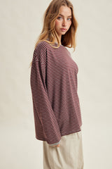 woman wearing a maroon and cream striped long sleeve top with a relaxed fit and round neckline