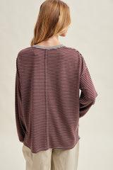 woman wearing a maroon and gray striped long sleeve top showing a relaxed fit and back seam detail