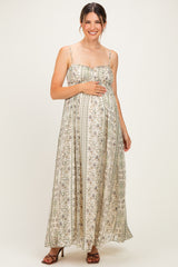 woman wearing a floral print maternity maxi dress with adjustable straps and a visible baby bump