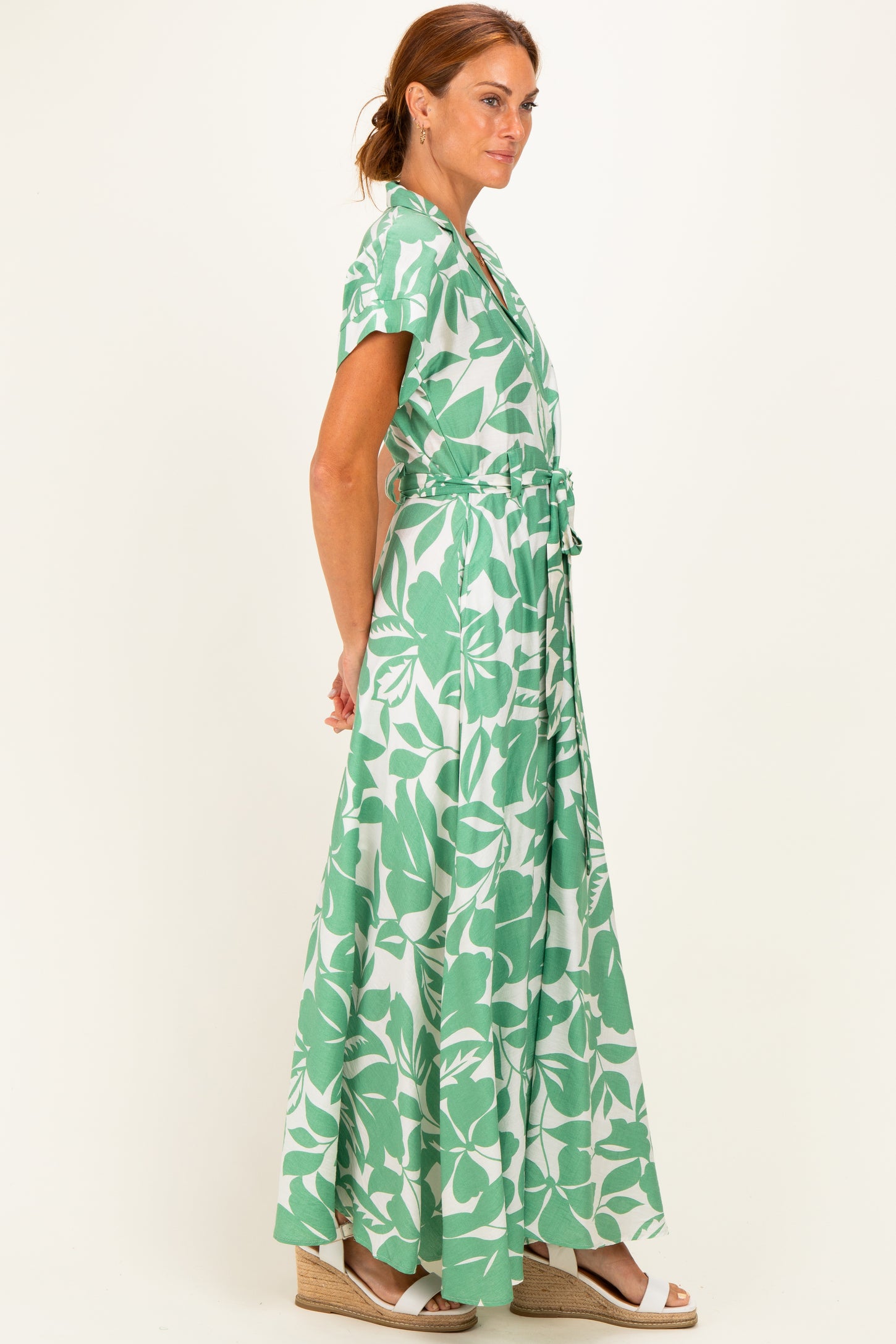 woman wearing a green floral maxi dress with short sleeves and a waist tie