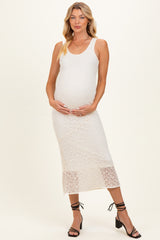 woman wearing a white lace maternity dress, styled with a fitted silhouette, holding her baby bump