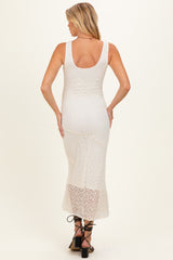 woman wearing a cream lace maternity dress with a fitted silhouette and flared hem, showing her baby bump from the back