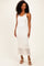woman wearing a white lace midi dress with a fitted tank top and a tiered skirt design