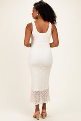woman wearing a white lace maxi dress with a fitted silhouette and a sheer bottom hem, viewed from the back
