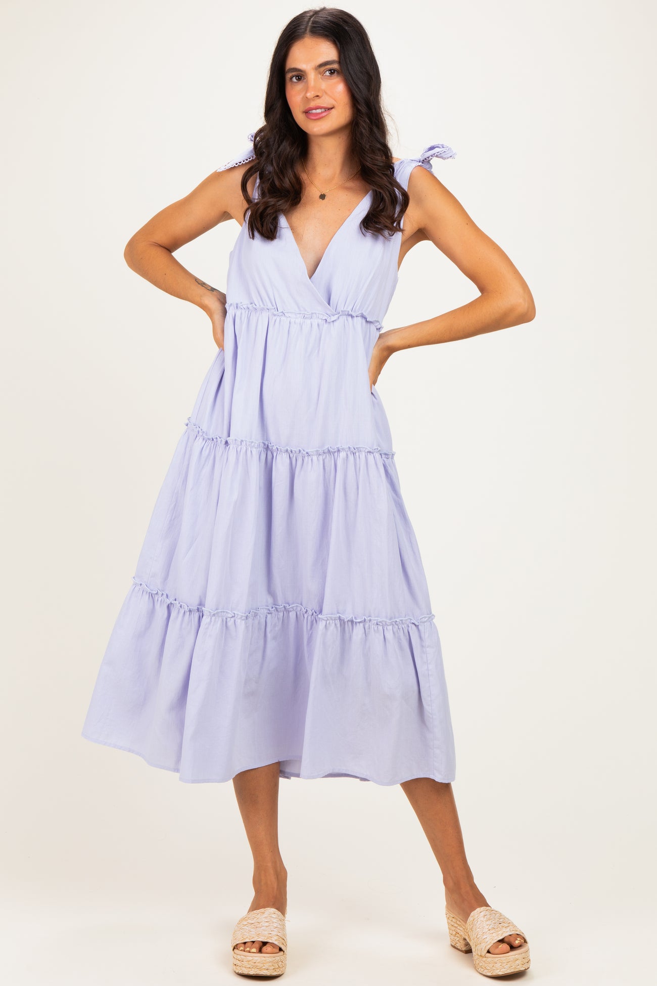 woman wearing a lavender tiered maxi dress with adjustable tie straps and a v-neckline, posing with hands on hips