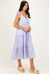 woman wearing a lavender tiered maxi dress with tie shoulder straps and a plunging neckline