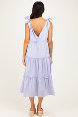 woman wearing a lilac tiered maxi dress with bow tie straps and a v-back detail
