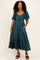 woman wearing a dark green midi dress with puff sleeves and a tiered skirt, holding a black handbag