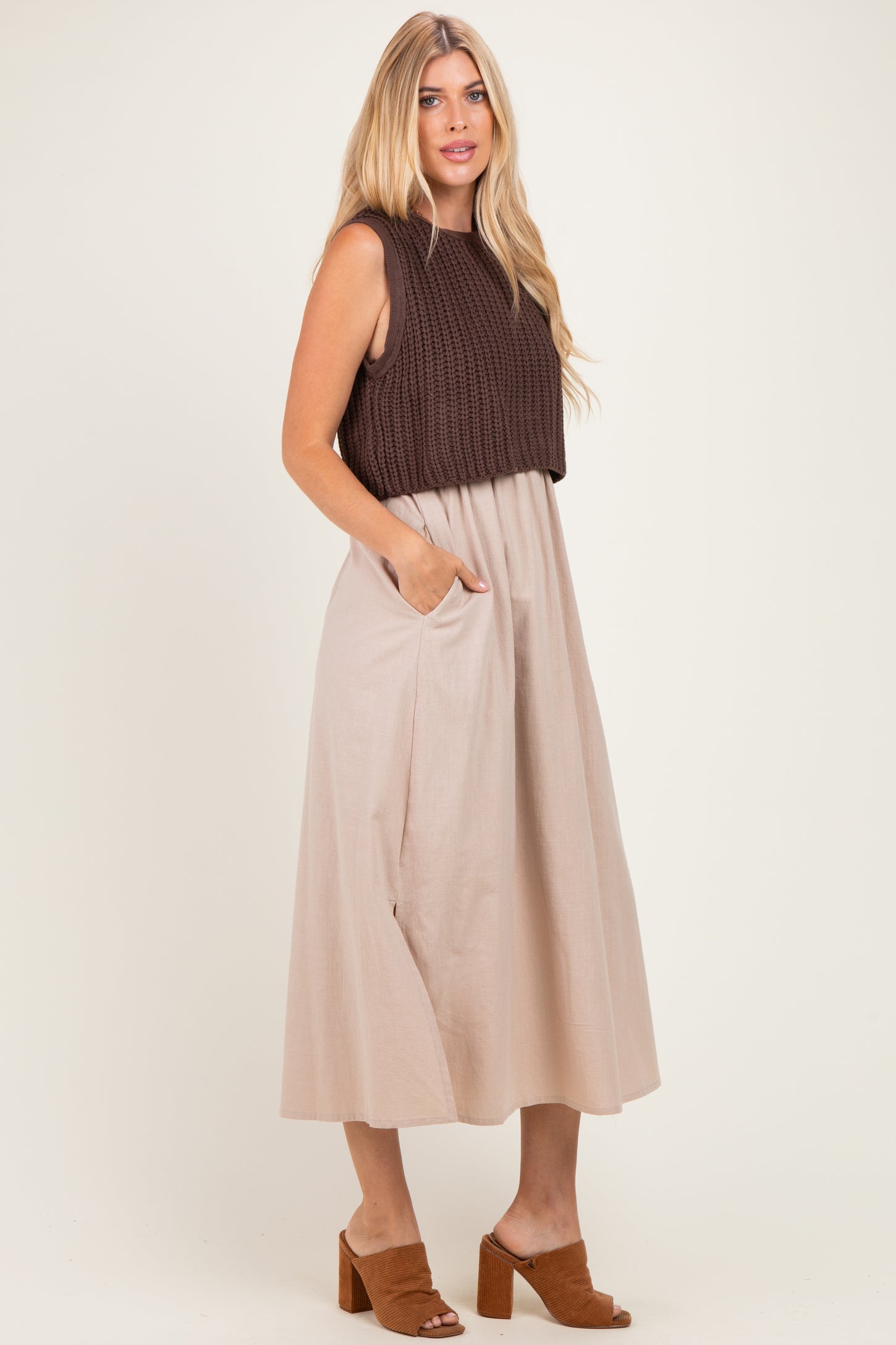 woman wearing a brown knit sleeveless top and a beige midi skirt with pockets, styled with tan heeled mules