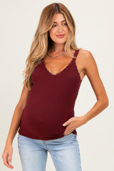 woman wearing a burgundy maternity tank top with lace trimming and a visible baby bump