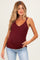woman wearing a burgundy maternity tank top with lace trimming and a visible baby bump