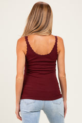 woman wearing a maroon maternity ribbed tank top with lace trim and showing a baby bump