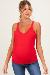 woman wearing a red maternity tank top with lace trim and showing her baby bump while posing