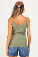 woman wearing a sage green maternity tank top with scalloped edges and denim shorts