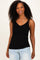 woman wearing a black ribbed tank top with scalloped edges and spaghetti straps, smiling with curly hair