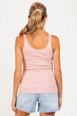 woman wearing a light pink maternity tank top with lace trim and a fitted style