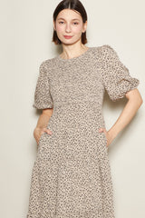 woman wearing a beige floral print puff sleeve dress with pockets