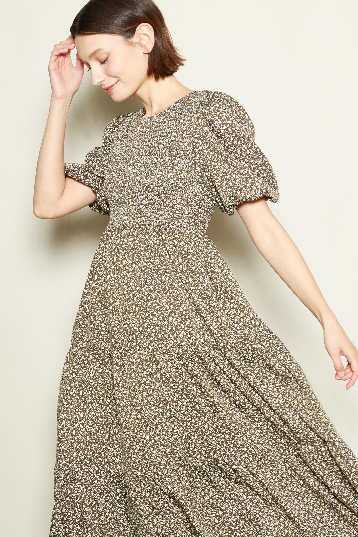woman wearing a brown floral puff sleeve maxi dress with a flowing skirt