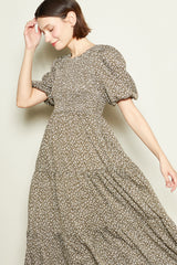 woman wearing a brown floral puff sleeve maxi dress with a flowing skirt